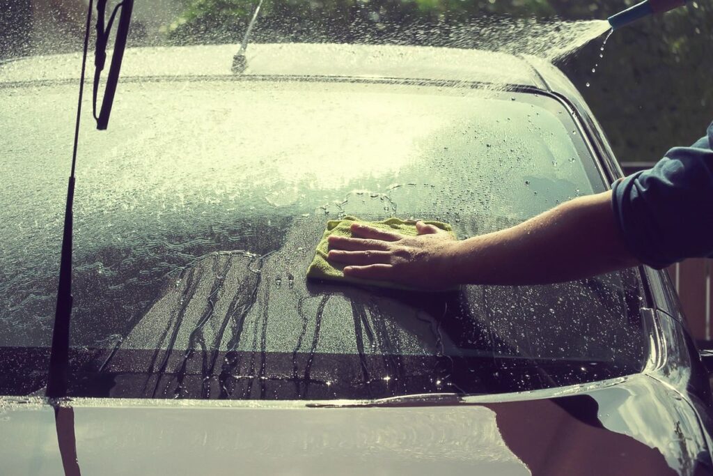 A person wiping the car