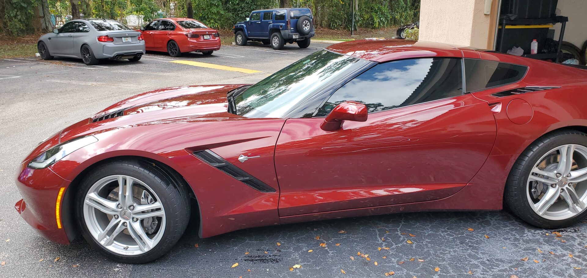 A red corvette parked in the parking lot.