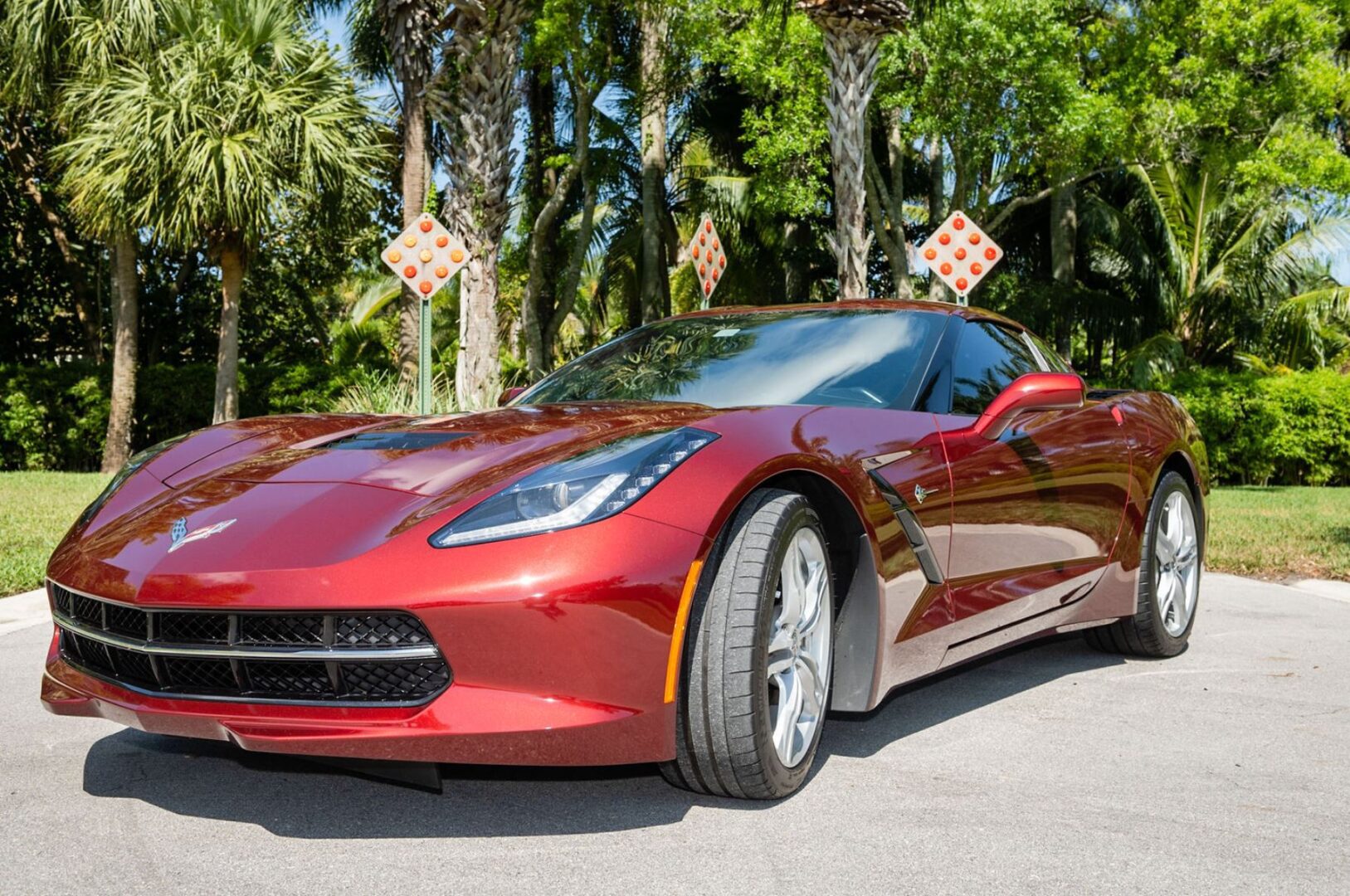 A red corvette parked on the side of a road.